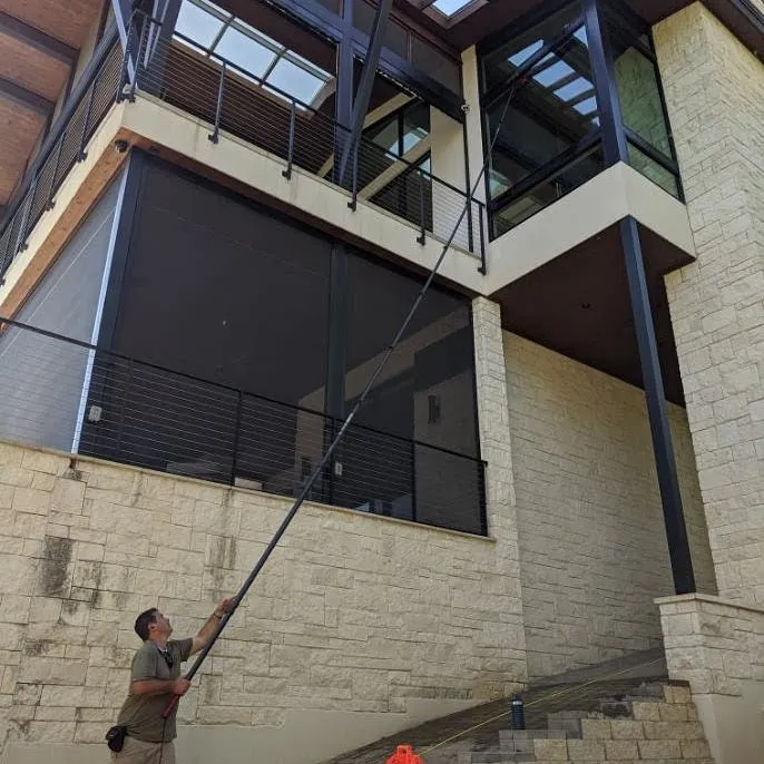 Professional window cleaning services restoring clean windows on a house in Austin TX.